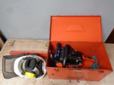 A Dolmar chain saw in a fitted metal box together with protective helmet and ear defenders