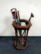 An Edwardian hexagonal stick stand containing walking cane with silver pommel, shooting stick,