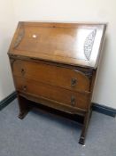 A 20th century oak writing bureau fitted two drawers beneath