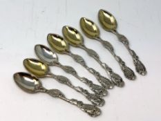 An ornate set of seven silver-gilt teaspoons. CONDITION REPORT: 108g gross.