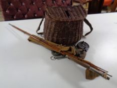 A vintage wicker fishing creel containing reels, case of flies,
