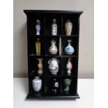 A wooden display stand containing 12 miniature vase collection,