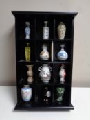 A wooden display stand containing 12 miniature vase collection,