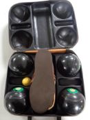 A leather case of a set of four Taylor lawn bowls and a pair of bowling shoes