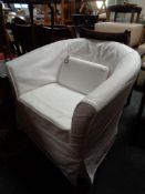 A contemporary tub chair with a white loose cover