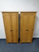 A pair of contemporary oak narrow double door cabinets fitted shelves