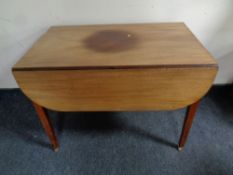 A 19th century mahogany drop leaf table on brass casters