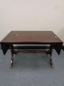 A continental flap sided coffee table with under stretcher on brass capped feet