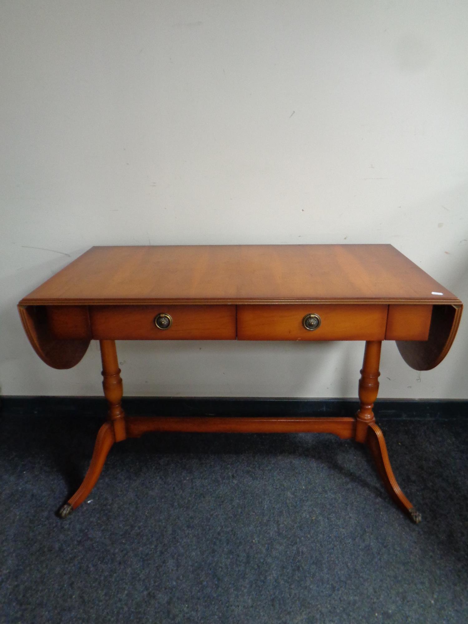 A yew wood drop leaf sofa table fitted two drawers