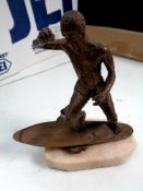 A bronze sculpture of a surfer, initialed A. G.