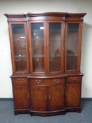 A Regency style inlaid mahogany four door glazed bookcase fitted cupboards and drawers beneath