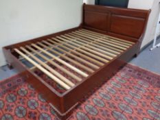 A 6ft contemporary sleigh bed together with pair of matching bedside cabinets in a mahogany finish