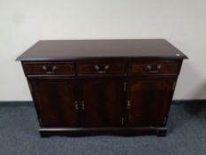 A Regency style inlaid mahogany triple door sideboard fitted three drawers