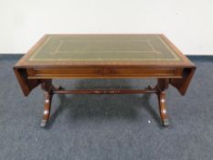 A mahogany flap sided sofa coffee table with a tooled green leather inset panel ,