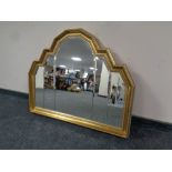 A decorative shaped gilt framed bevel edged sectional mirror