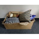 A box containing home cushions, throws, window blinds,