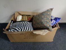 A box containing home cushions, throws, window blinds,