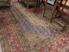 A fringed Persian design floral carpet on beige ground 347 cm x 274 cm.