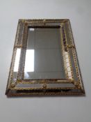 A contemporary brass framed cushion mirror 45 cm x 32 cm.