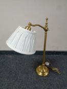 A contemporary brass adjustable table lamp