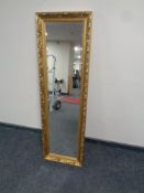 An ornate gilt framed bevel edged hall mirror 41.5 cm x 132.5 cm.