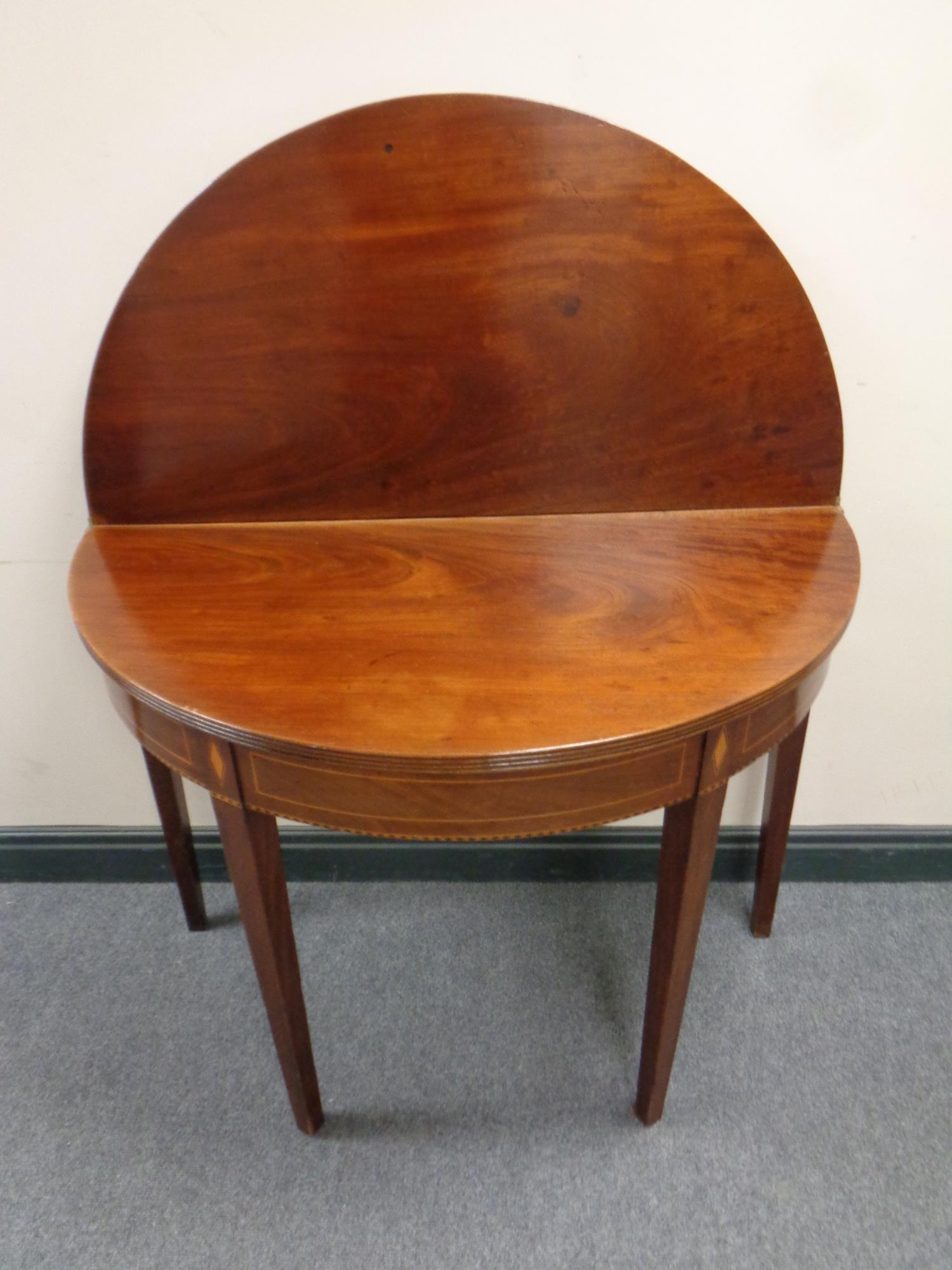 A 19th century inlaid mahogany demi lune turnover top tea table