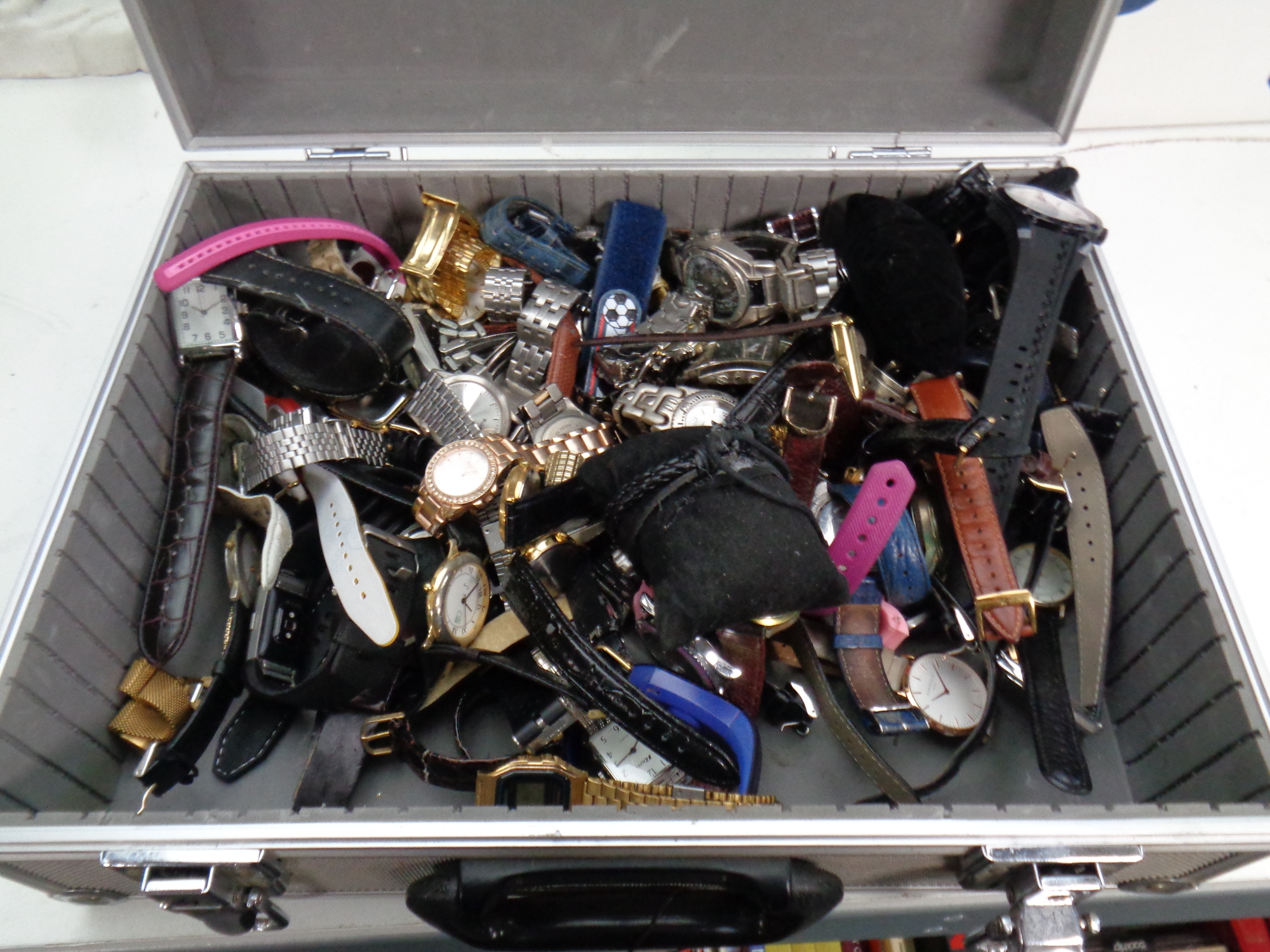 An aluminium case containing a large quantity of assorted lady's and gent's wristwatches