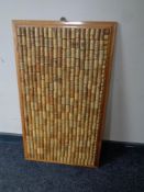 A collection of wine bottle corks mounted in a pine frame
