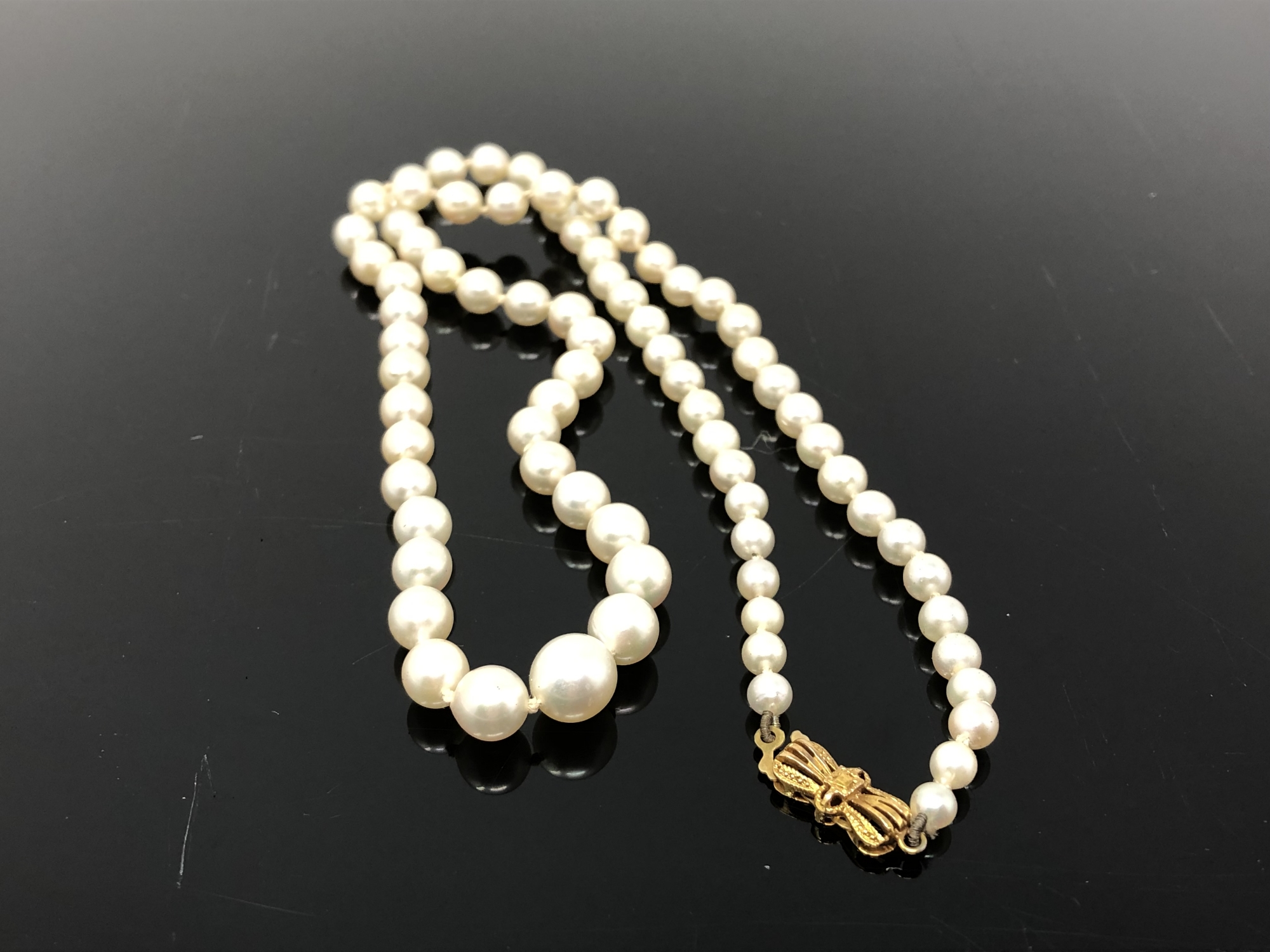 A strand of pearls with gold clasp