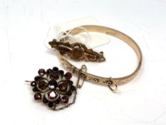 A 9ct gold bangle, 6.4g, together with two antique yellow metal brooches one is set with garnets.