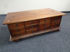 An eastern mahogany storage coffee table fitted twelve drawers