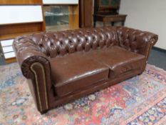 A brown button back Chesterfield two seater settee