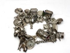 A heavy silver charm bracelet with many charms. CONDITION REPORT: 115.