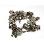 A heavy silver charm bracelet with many charms. CONDITION REPORT: 115.