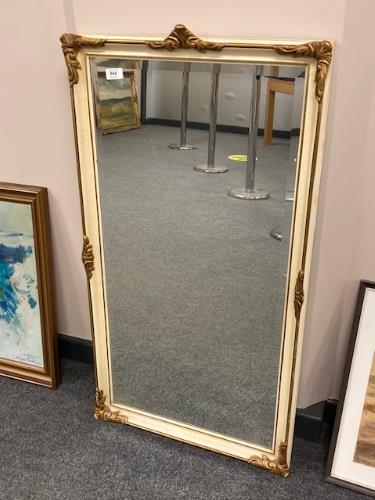 A cream and gilt framed bevelled mirror,