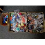 Two boxes and a bag containing a very large quantity of McDonald's Happy Meal toys ,