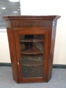 A 19th century mahogany glazed door hanging corner cabinet fitted shelves
