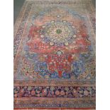 A fringed Persian floral patterned carpet on pink ground 335 cm x 240 cm.