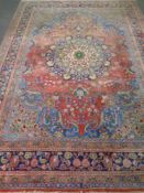 A fringed Persian floral patterned carpet on pink ground 335 cm x 240 cm.