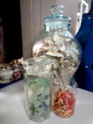 Three glass storage jars containing shells,