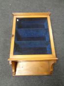 A late 19th century glazed door wall cabinet fitted shelves lined with a blue velvet fabric