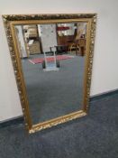 A decorative gilt framed bevel edged mirror 94 cm x 64 cm.