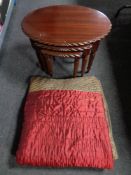 A nest of three tables in a mahogany finish and a quilt