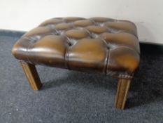 A brown button leather Chesterfield footstool on wooden legs