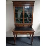 A late 19th century oak Arts & Crafts writing desk with glazed bookcase above