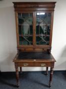 A late 19th century oak Arts & Crafts writing desk with glazed bookcase above