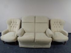 A Parker Knoll two seater settee together with pair of button back armchairs upholstered in a beige