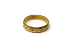 An 18ct gold band ring with engraved decoration, size L. CONDITION REPORT: 3.