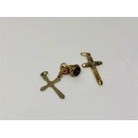 Two antique crucifix pendants together with a further charm