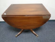 A Regency style inlaid mahogany drop leaf pedestal table